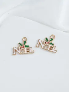 Detail of DIY Christmas Noel charms with green leaves and red berries for jewelry
