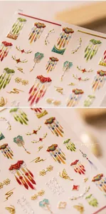 Macro detail of 3D embossed nail stickers featuring traditional red tassels and golden clouds