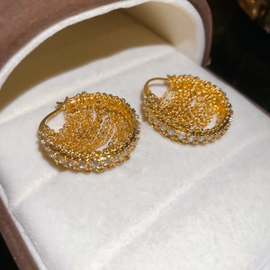 Detail of 18k gold plated hoop earrings with layered chains and cubic zirconia in a jewelry box