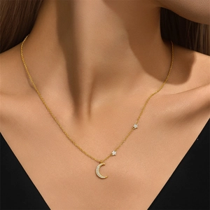Detail of gold moon and star pendant necklace with sparkling diamonds on neck