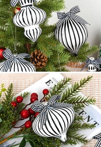 Close-up of black and white striped glass ornaments with bows on a Christmas tree