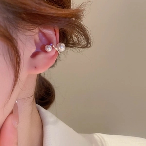 Close-up of pearl and zircon ear cuff on ear without piercing for minimalist style