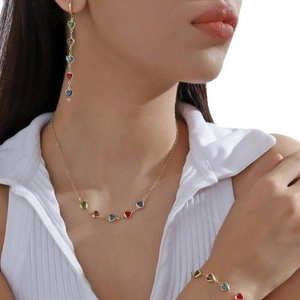 Parure de bijoux dorés avec pendentifs cœurs colorés comprenant boucles et collier
