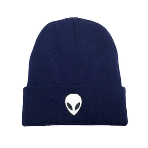 Close-up of white alien head embroidery on dark blue ribbed knit beanie cuff