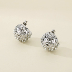 Macro detail of silver hemispherical earrings with white pearl inlay and stud backing