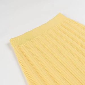 Vue détaillée d'une jupe plissée jaune en maille montrant la texture à côtes et la taille