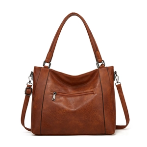 Detail view of the vintage brown tote bag showing textured leather and adjustable strap
