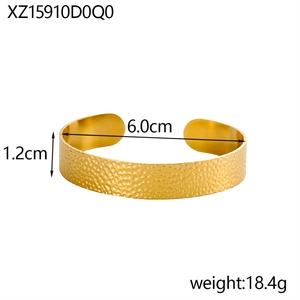 Detail view of gold hammer textured wide open bangle with 1.2cm width and 6cm diameter