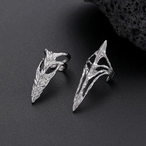 Detailed view of punk silver joint rings with clear zircon inlay on a dark stone background
