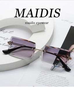 Detail of purple gradient lenses and gold metal hinges on rimless rectangle sunglasses