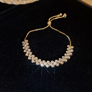 Detail of gold double-row zircon bracelet with adjustable slider clasp on black velvet