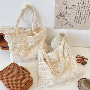Close-up of the intricate floral lace crochet pattern on a cream canvas tote bag