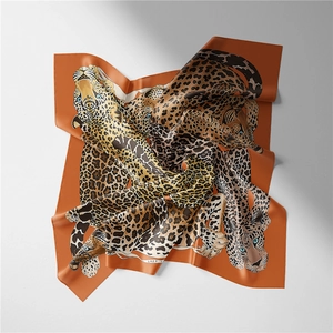 Detailed view of luxury silk scarf featuring vibrant leopard print on orange background