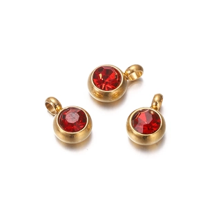 Detailed view of three gold pendant charms featuring vibrant red faceted zircon stones