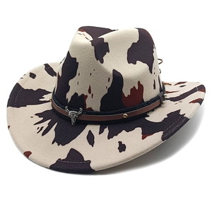 Western cowboy hat with cow print felt, steer skull buckle and golden rivets on black band