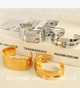 Detailed view of irregular wavy gold and silver plated titanium steel open cuff bangles