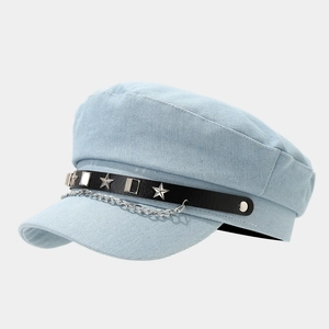 Detailed shot of light blue denim military hat with silver star studs and metal chains