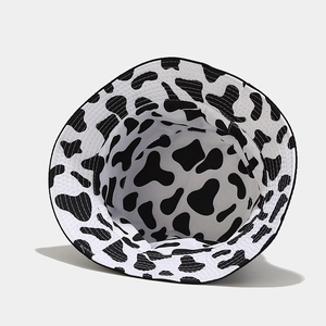 Reversible bucket hat with black and white cow pattern and reinforced stitching details