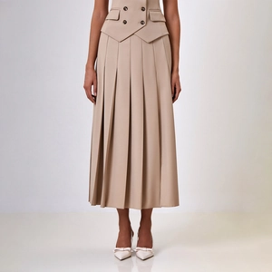 Détail de la jupe plissée beige et de la veste croisée avec poches à rabat