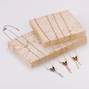 Close-up of 3D butterfly tassel necklaces in silver, gold, and rose gold finishes