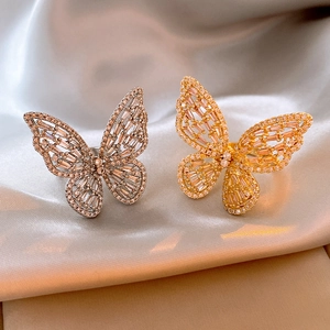 Detailansicht der silbernen und goldenen Schmetterlingsringe mit Zirkonia auf Seide