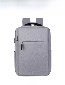 Front view of grey business backpack showing USB charging port and waterproof fabric