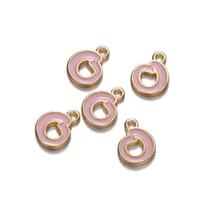 Detailed macro view of gold-plated pink enamel alphabet pendants for DIY jewelry sets
