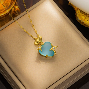 Detailed shot of gold necklace featuring a blue heart pendant with stars and diamonds