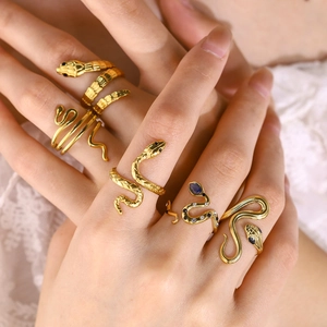 Detail of 18K gold-plated snake rings with blue zircon set against white lace fabric