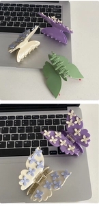 Detail of floral butterfly claw clips in purple and cream with metal spring and matte finish