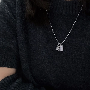 Detail of silver ball chain necklace with two bear pendants and shimmering zircon stones