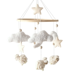 Detail of wooden baby crib mobile with sheep, cloud and star plush hanging ornaments