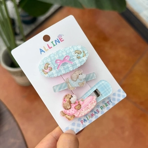 Close-up of three acrylic dog bow hair clips on branded card packaging