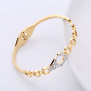 Dettaglio del bracciale in metallo dorato con pavé di strass e design a cerchio cavo