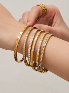 Dettaglio di bracciali a strati in acciaio inossidabile placcato oro 18K con zirconi