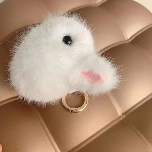 Cute white plush bunny head keychain with gold ring on a quilted background