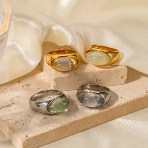 Dettaglio di anelli in oro 18k e argento con grandi pietre ovali in resina su pietra
