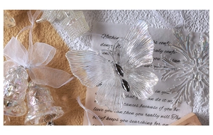 Iridescent Christmas ornaments set featuring a butterfly, bells, and a snowflake design
