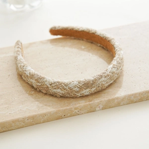 Macro detail of French vintage beige tweed headband on a marble background