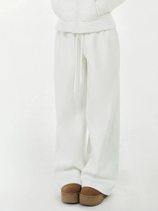 Détail du pantalon de jogging blanc large montrant le tissu épais et le cordon de serrage