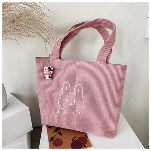 Detail of pink corduroy tote bag with rabbit embroidery and cute cow pendant