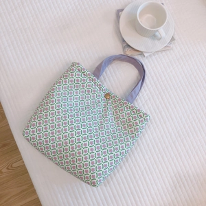 Green floral canvas lunch tote bag with purple strap and vintage button closure