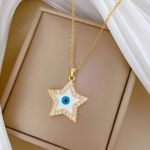 Detail of gold star pendant necklace with white enamel, blue eye and pavé crystals