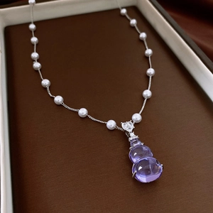 Detail of purple gourd pendant with pavé crystals and pearl-embellished silver chain