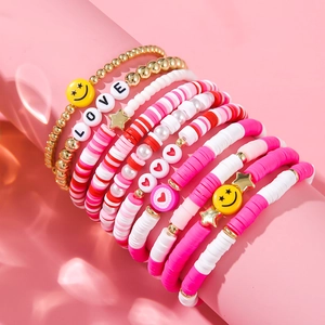 Close-up of multilayered beaded heart bracelets with LOVE charms and smiley beads