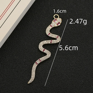 Exaggerated 18K gold plated snake pendant with white zircon pavé and red gemstone accents