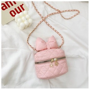 Detail of pink quilted crossbody bag featuring a large bow and floral gold zippers