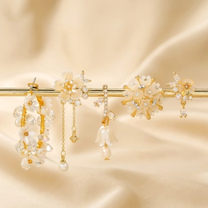 Elegant 18K gold floral earrings set featuring pearls and zircon on silk background