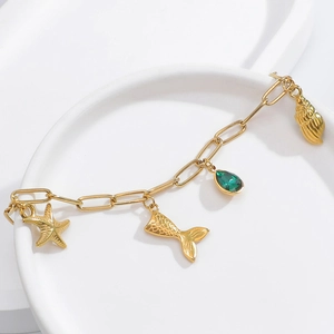 Close-up of 18K gold plated chain bracelet with starfish and green gemstone charms