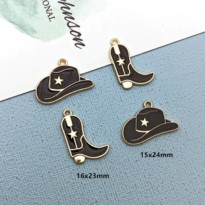 Detailed view of black enamel western cowboy hat and boot charms with white star patterns